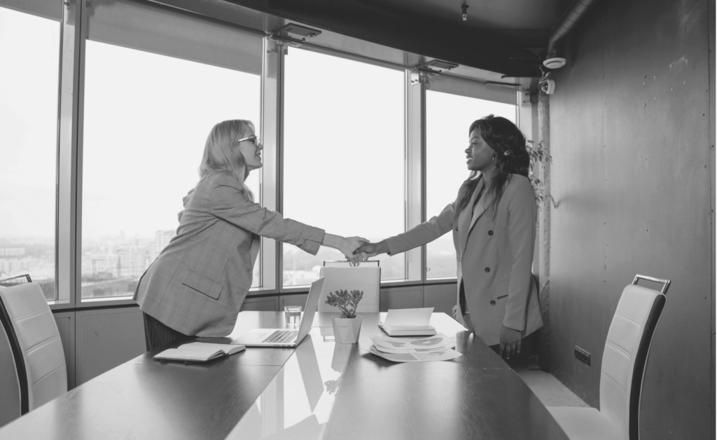 This image of two colleages shaking hands illustrates our discussion topic: A phishing email, and other cyberthreats, affecting US industries like finance and pharmaceuticals.