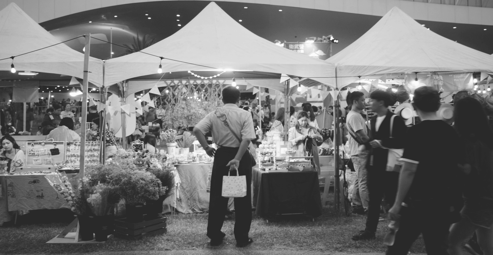 This image of a man at a shopping market with a bar behind his back illustrates this discussion topic: A counterfeits definition, and what it means for brands in the fight agains counterfeiting.