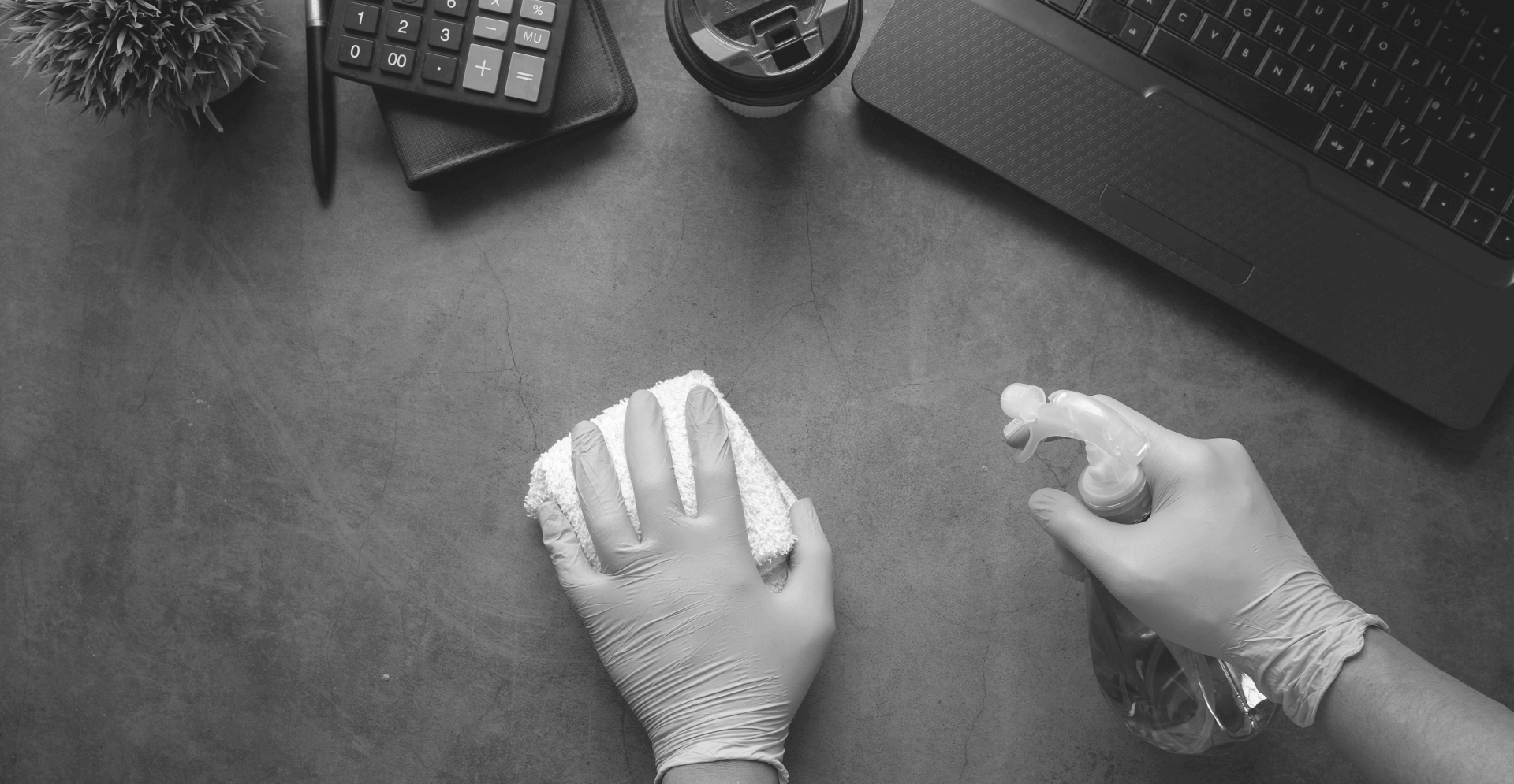 This image of gloved hands cleaning a computer desk highlights our discussion topic: Cyber hygiene, how businesses undervalue it, and its potential for digital risk protection.