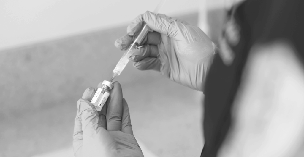 This image of a gloved hand using a syringe illustrates our discussion topic: counterfeit health products, their impact on consumers, and the role of brands in fighting back.