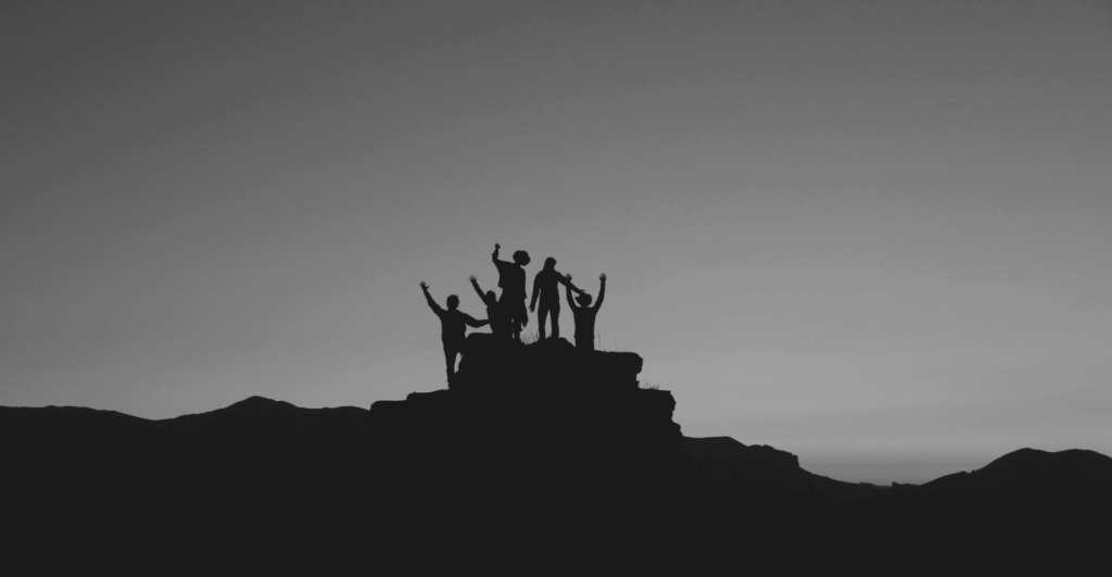 This image of hikers silhouetted celebrating on a mountaintop illustrates our discussion topic: Objection handling for ICANN's new domain registration phase.