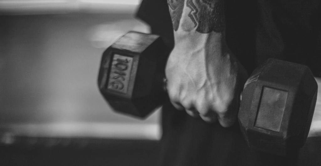 This image of a muscular hand lifting a weight illustrates our discussion topic: Fitness counterfeits and online scams from jerseys to protein powder, and how brands can fight back/
